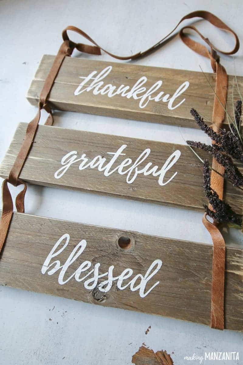 Close up of the rustic leather sign that says thankful grateful blessed and dried grass on the side