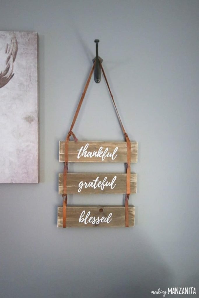 This DIY "thankful, grateful, blessed" wooden pallet sign is an easy rustic style DIY with just a few supplies. The sign hangs on a wall with long leather straps attached to each pallet.