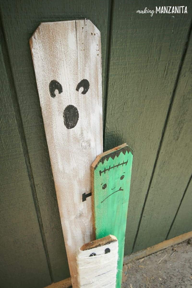 Ghost, Frankenstein and Mummy made from repurposed fence boards! Such a cute and simple way to create cheap Halloween porch decorations.