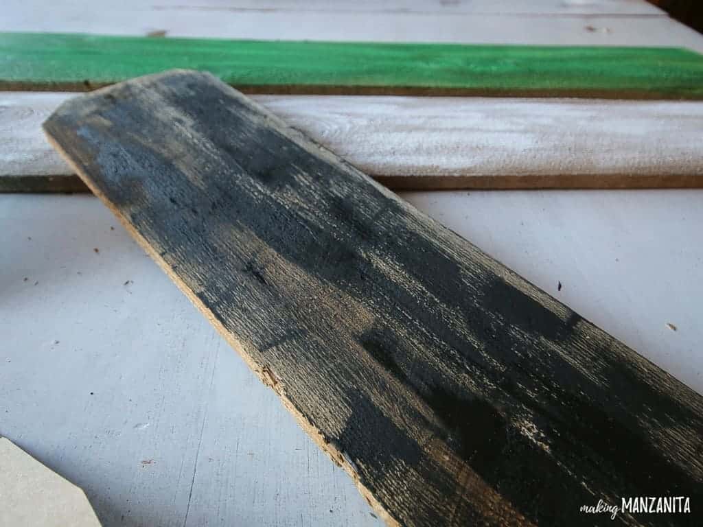 Paint an old reclaimed wood board black and transform it into a mummy Halloween decoration for your front porch. 