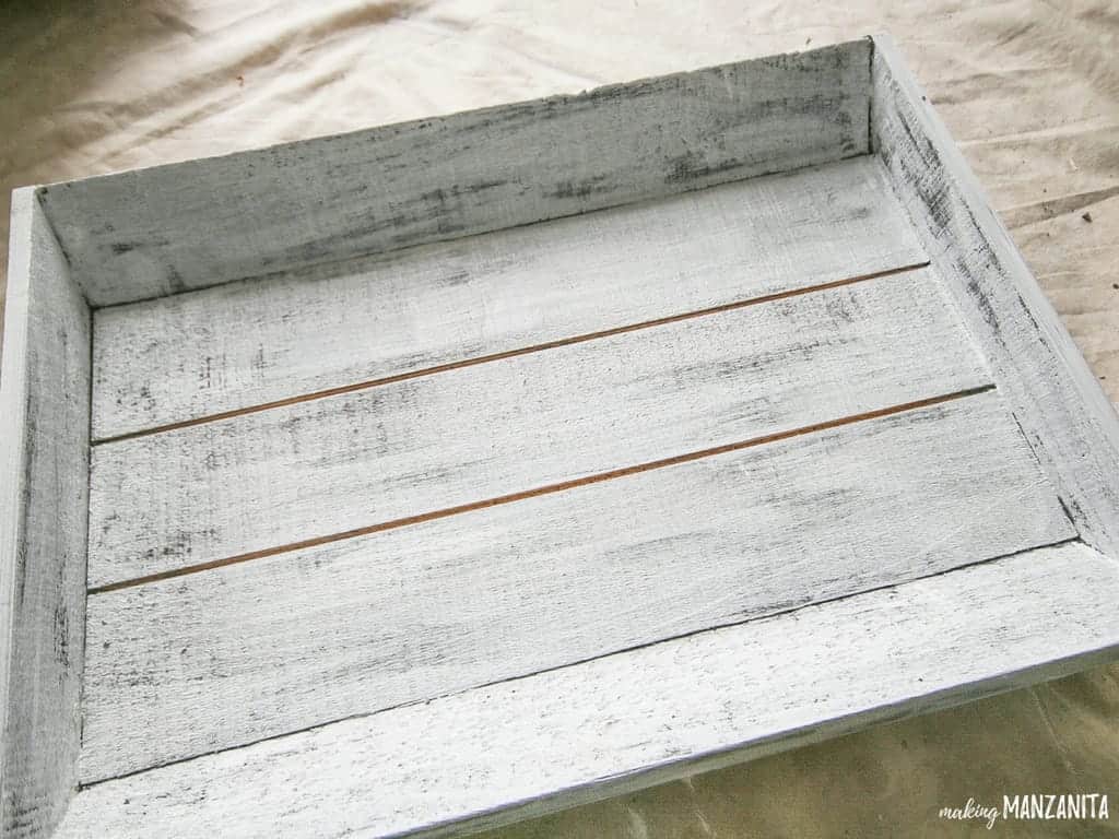 White wash painted wood tray over stained surface to create farmhouse advent calendar for Christmas countdown