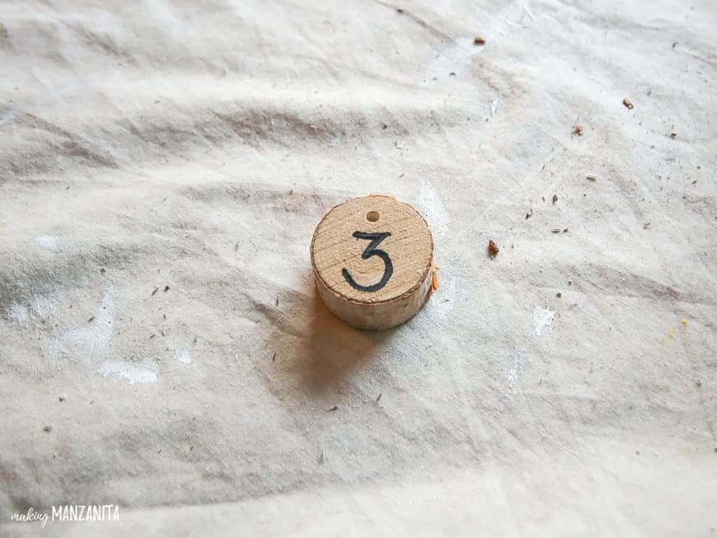 Use permanent marker to write numbers on wood rounds for the Christmas countdown