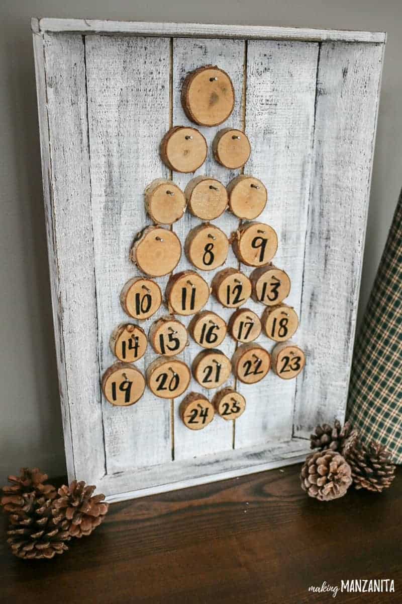 Walnut hollow birch wood rounds with numbers and others turned on the other side nailed to the farmhouse painted wood tray for the Christmas advent countdown calendar