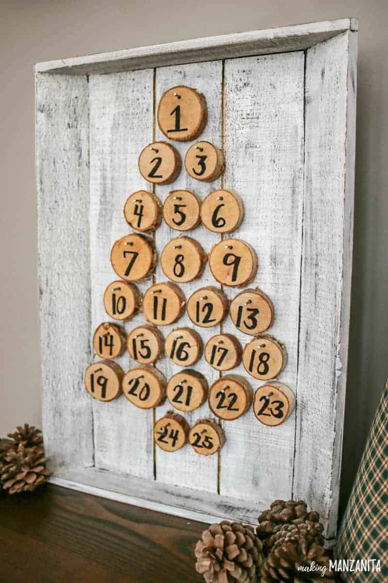 Farmhouse style painted wood tray with wood rounds in a Christmas tree shape for a creative DIY rustic Christmas advent calendar. I love this idea for a Christmas countdown! Turn the wood rounds over to count down the days til Christmas. Easy Christmas craft you can do with kids | Christmas countdown sign | Wood rounds with numbers | Countdown board | Homemade Christmas advent calendar | Wood tags | Advent calendars to hang on the walls 