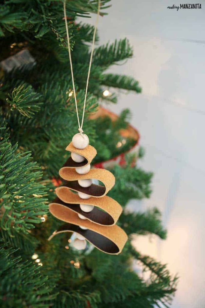 A detailed close-up of a Christmas tree adorned with stylish leather ornaments, showcasing a blend of textures and earthy tones for a sophisticated and modern holiday display.