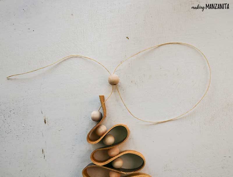 Showing detail of top for leather and wood beads on mini christmas tree ornament