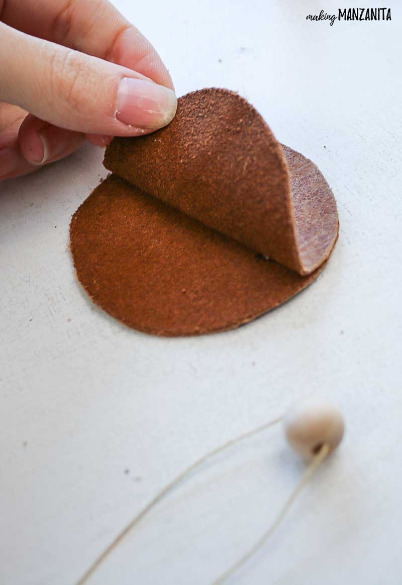 Place two leather circles on top of each other and prepare to glue them together using craft glue