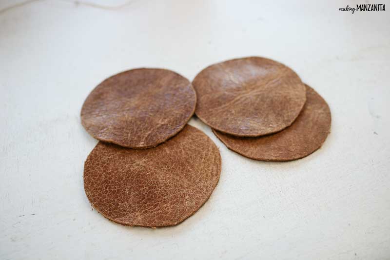 These leather circles are the first step in creating easy DIY leather Christmas ornaments for friends and family