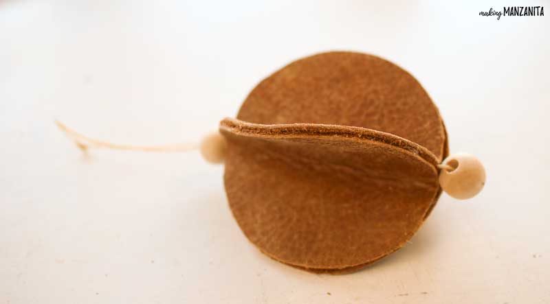 This DIY leather Christmas ornament couldn't be easier to make with a few circles of leather and some wood beads