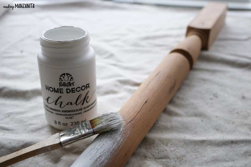 Use white chalk paint to paint the wooden spindle white - the first step in making this BELIEVE Christmas sign