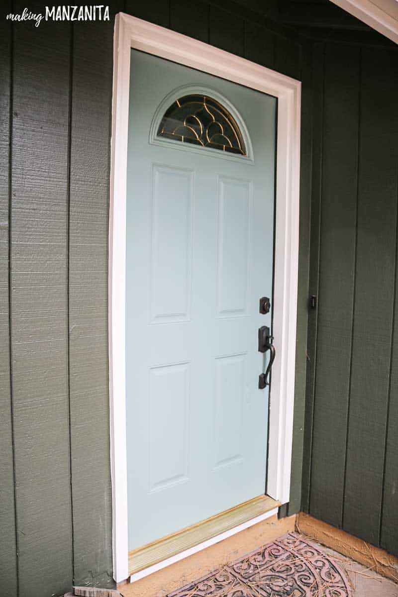 Our new front door looks great with our newly painted home exterior - a light greenish blue front door against dark green exterior walls.