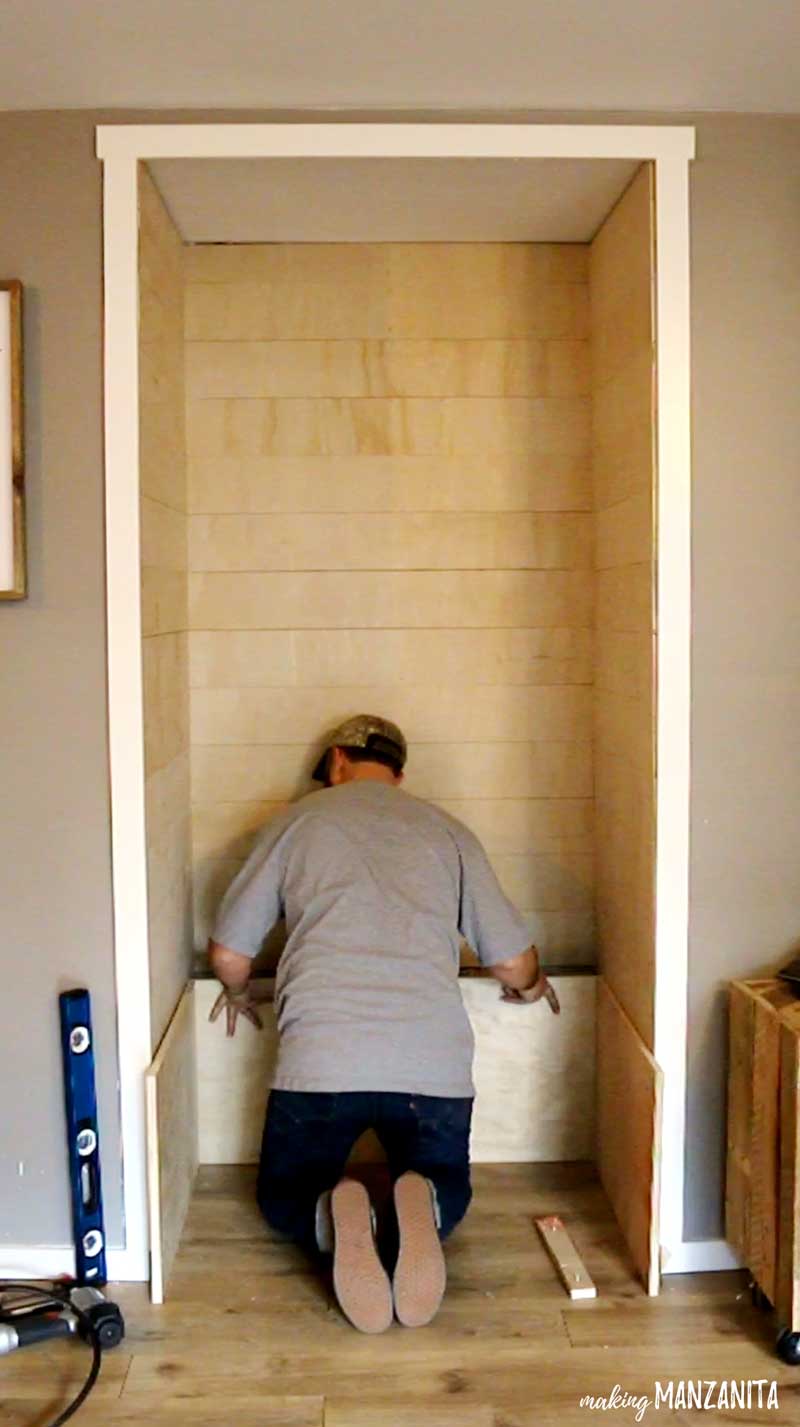 Logan has finished installing the shiplap walls, and is now installing the frame of the wood storage box - which will also be the bench - in the living room reading nook.