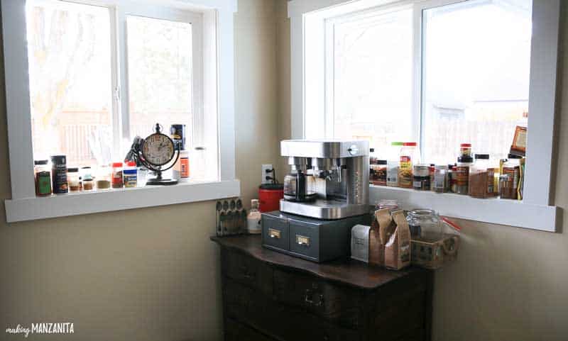 Here's how we stored our spices in our kitchen before our spice cabinet organization project; spice bottles stacked up, lining the window sills in our kitchen.