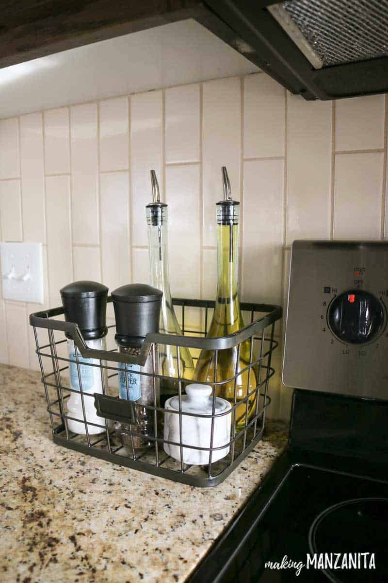 After our spice cabinet organization project, our kitchen counter is no longer cluttered with overflowing spices. Instead, we have a neatly organized basket with salt and pepper grinders, and cooking oil bottles.