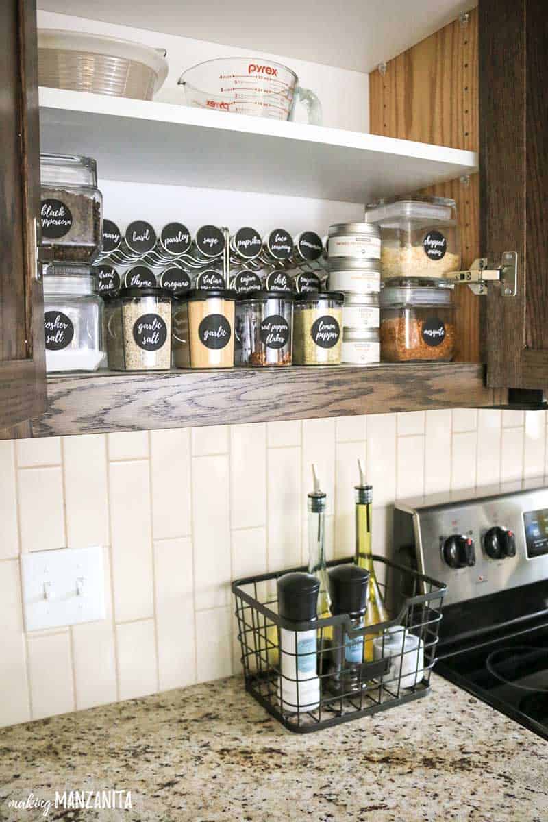 A brilliantly organized spice cabinet with clearly labeled spice jars using spice jar label stickers.