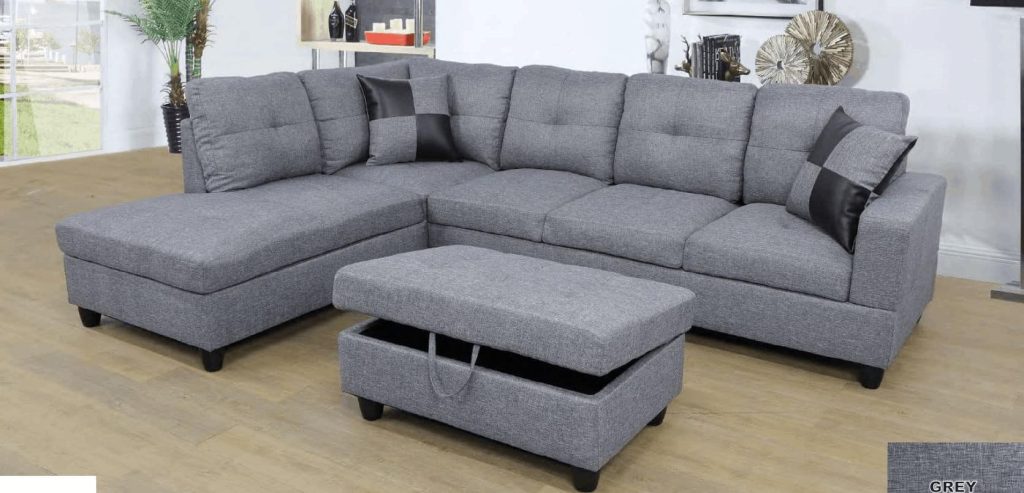 A microfiber gray sectional sofa with four seats, a chaise, and matching ottoman that opens for additional storage. Styled with matching gray and black checkered throw pillows.