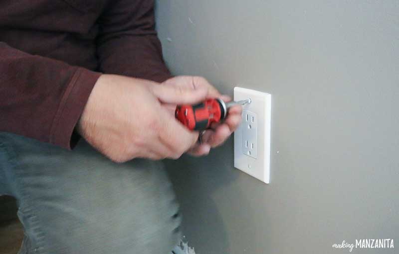 photo demonstrating the removal of a wall outlet cover