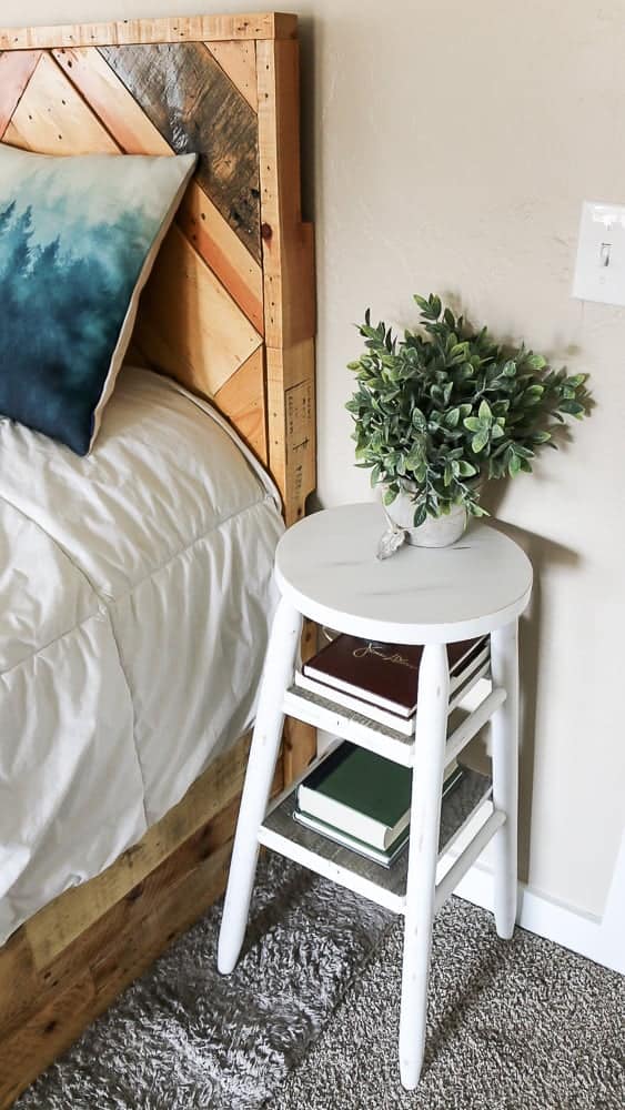 A look at how we're using our upcycled white barstools - as narrow bedside tables, we added shelves to store books and a potted plant.