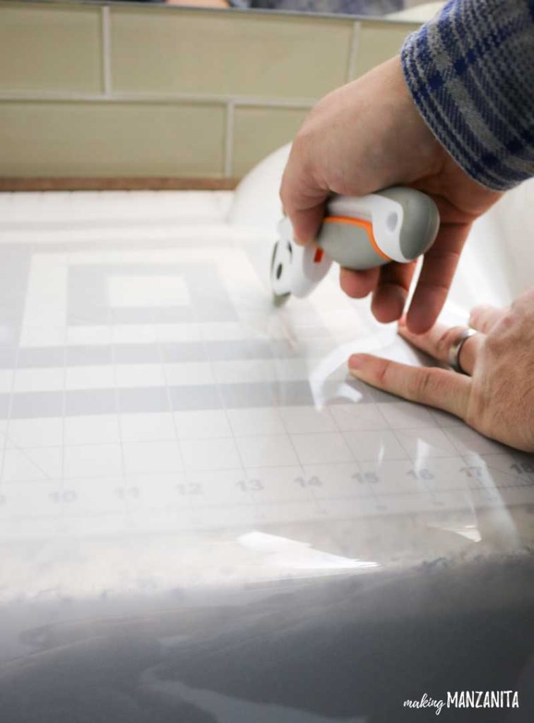 Using a cutting mat and a rolling blade knife to cut the frosted window film down to the correct size. 