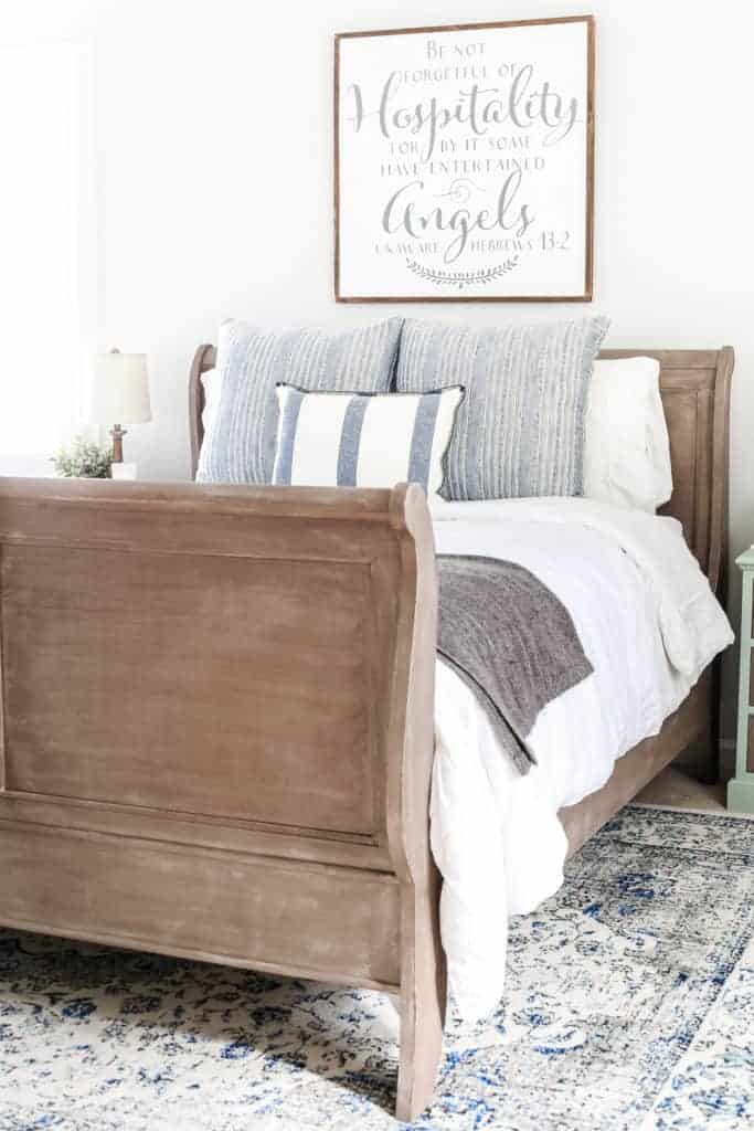 blue cottage style guest bedroom with farmhouse sign above bed