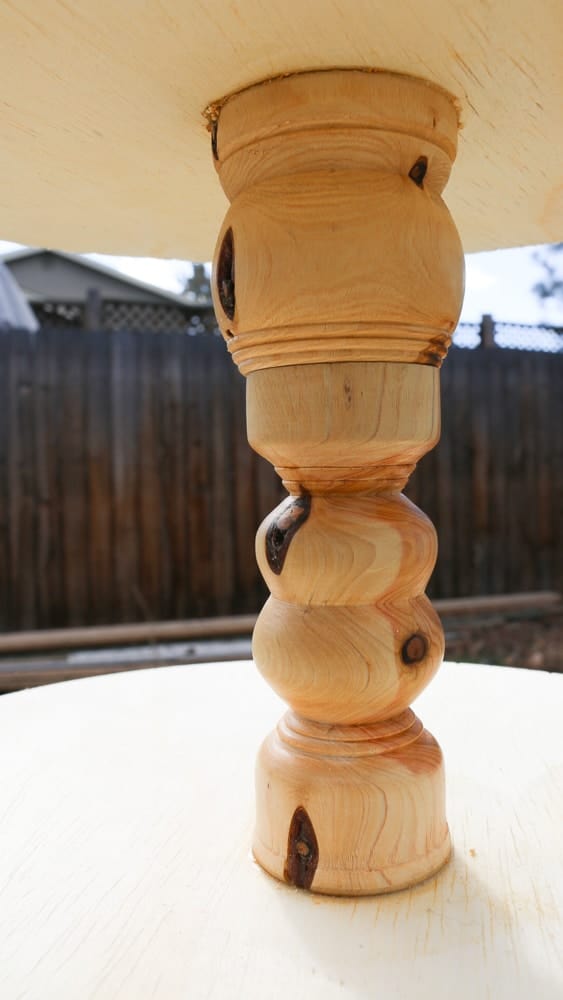 A close up look at one of the wood spindles between the tiers of the diy three tier stand.