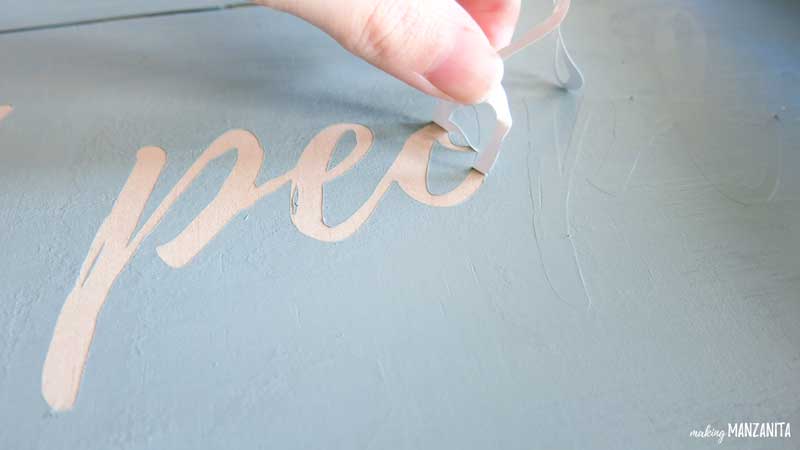 Peeling off the stenciled words on wood sign is simple once it gets started