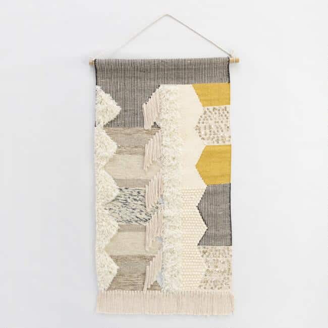 Do you need master bedroom wall decor ideas for above your bed? Try a boho style wall hanging, like this gray, white and yellow woven wall hanging from World Market