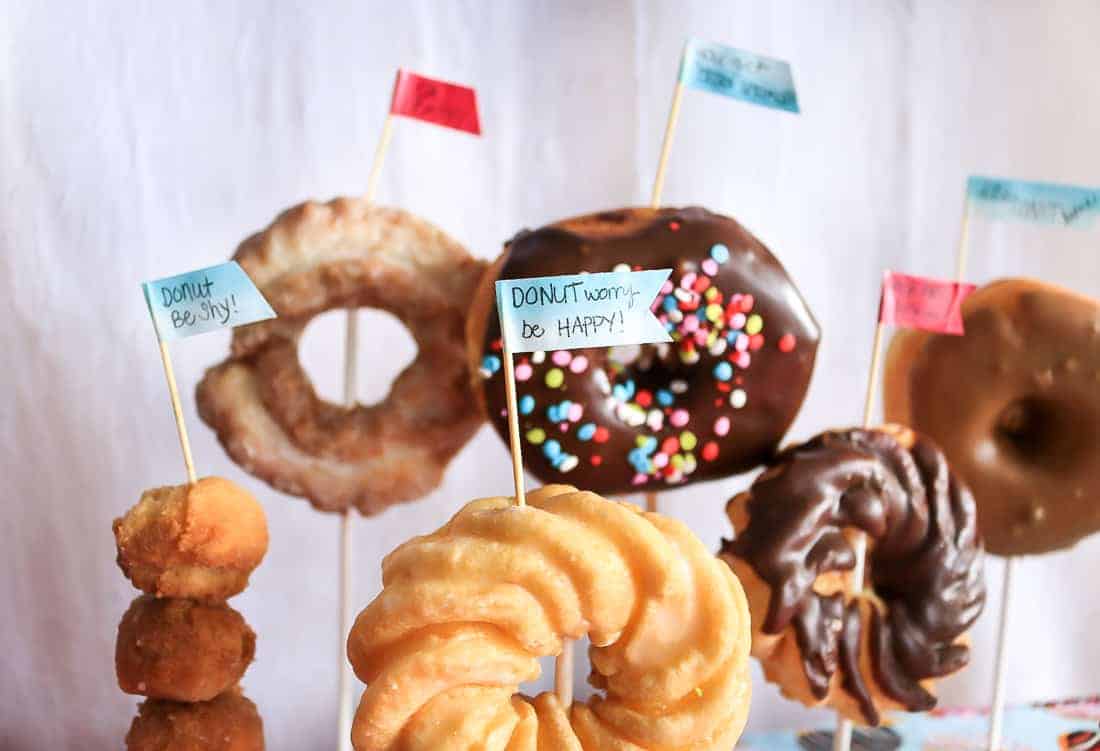 Donuts on sticks with washi tape flags with cute donut-themed sayings on them.