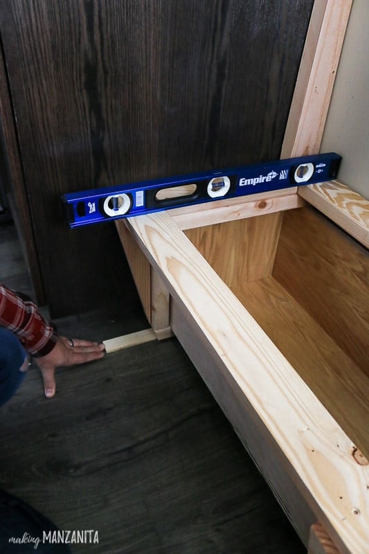 Level sitting on top of bench being built in breakfast nook for built in seating