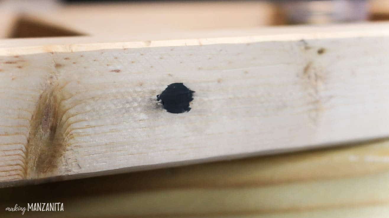 A close up look at the putty filling the screw holes on the baby blanket ladder frame.