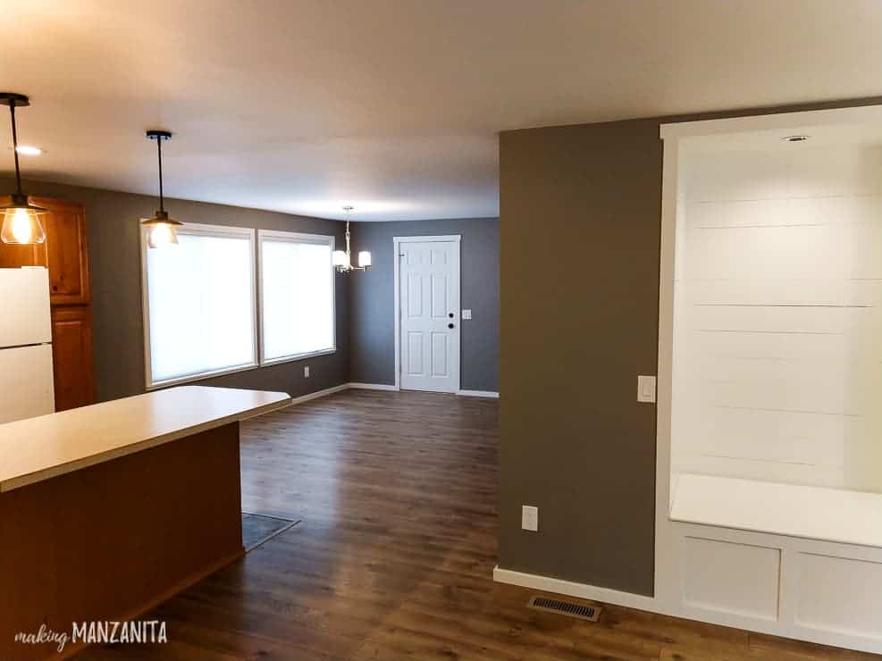 Our updated dining room as seen from the living room. The whole space is empty of furniture and has new hardwood flooring, painted walls, and new lighting.
