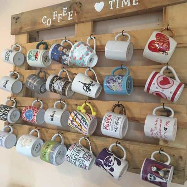 Wood pallet hanging on wall with hooks for coffee mugs 
