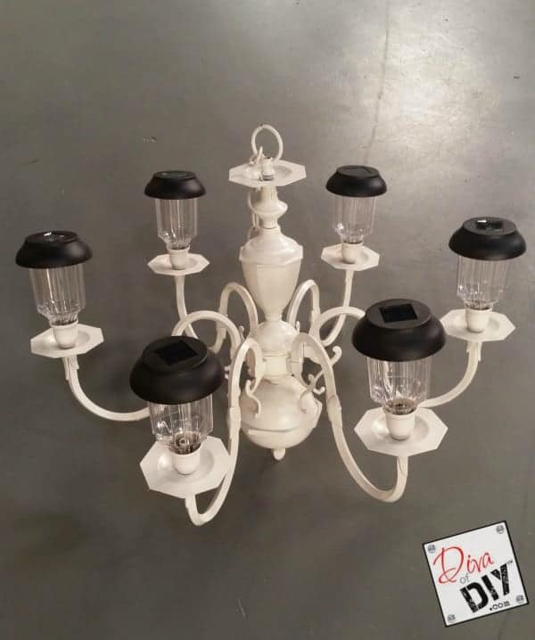 This upcycled chandelier is the perfect outdoor lighting fixture for a patio or walkway. The chandelier is painted a soft cream color; the lights are replaced with solar-powered outdoor lanterns.