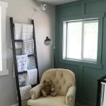 Nursery with chair, blanket ladder, black floor lamp with text overlay that says baby essentials checklist