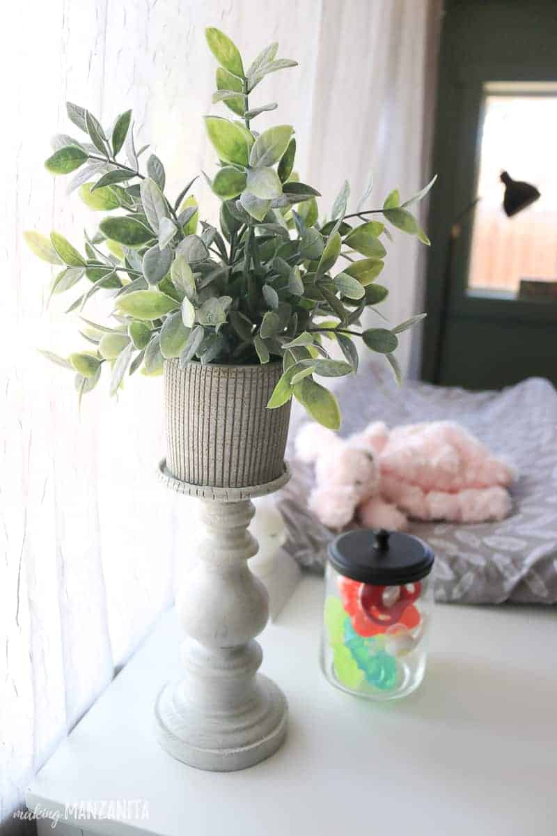 A faux plant in a wood candle holder is a great way to add a touch of decor to your organized changing table