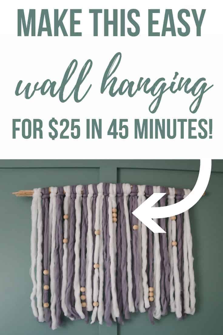 A boho style yarn hanging made with white and gray yarn hangs on a green wall. Text overlay reads 