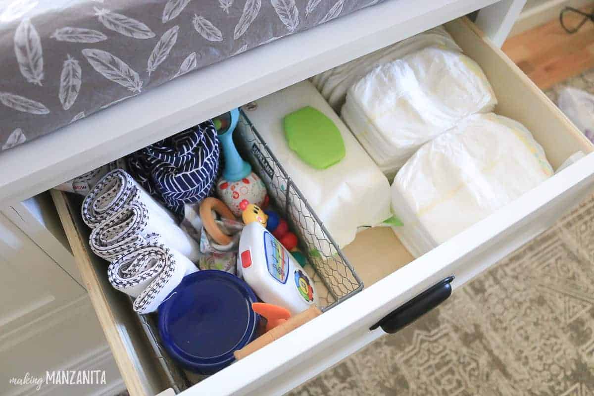 This changing table drawer is organized to hold diapers, diaper cream, wipes, changing pad liners, covers, and more