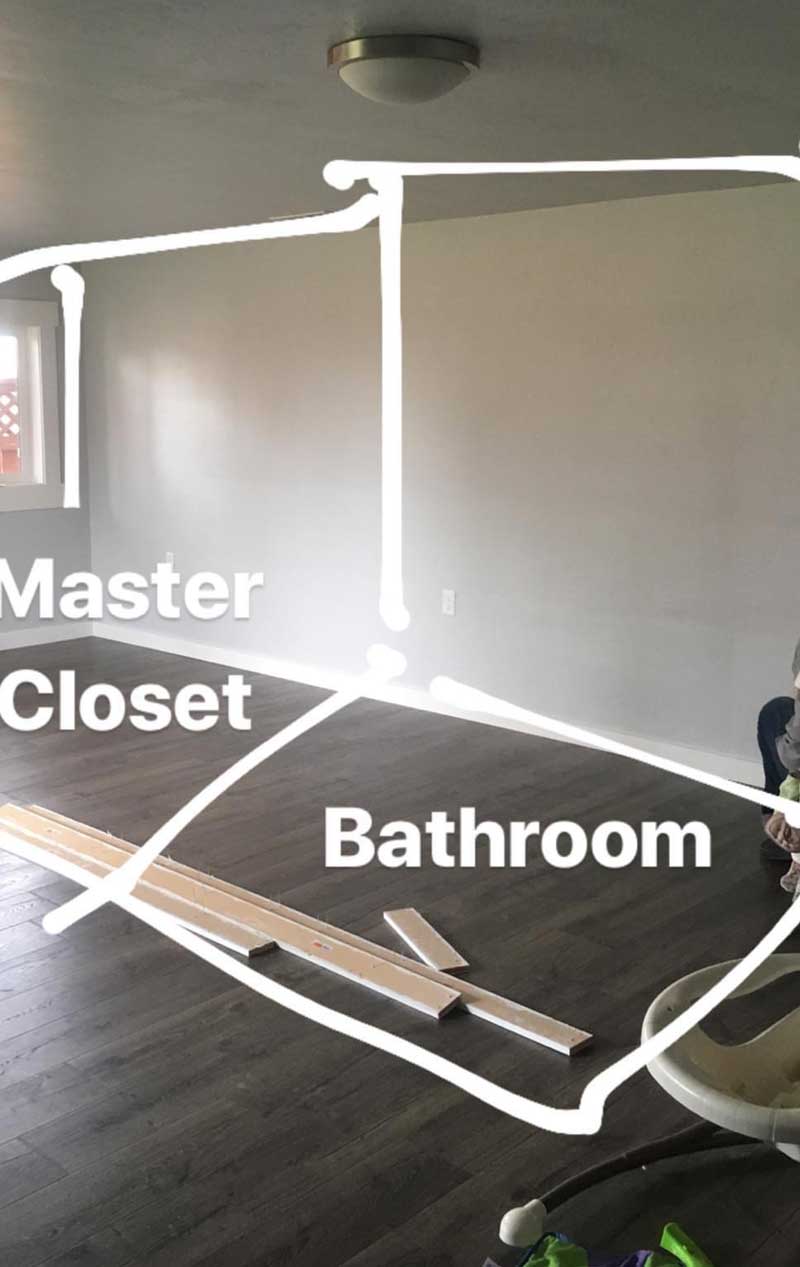 Photo of empty room with drawn on white lines showing where new walls would go to create a master closet and new boho farmhouse bathroom