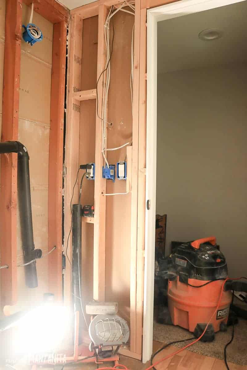 Bathroom makeover in progress picture showing drywall removed to rough in plumbing