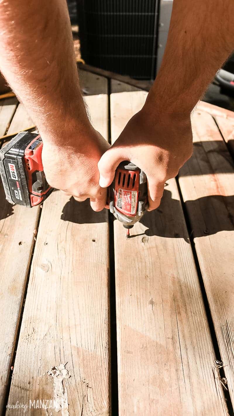 Vis de serrage homme avec perceuse sur terrasse en bois