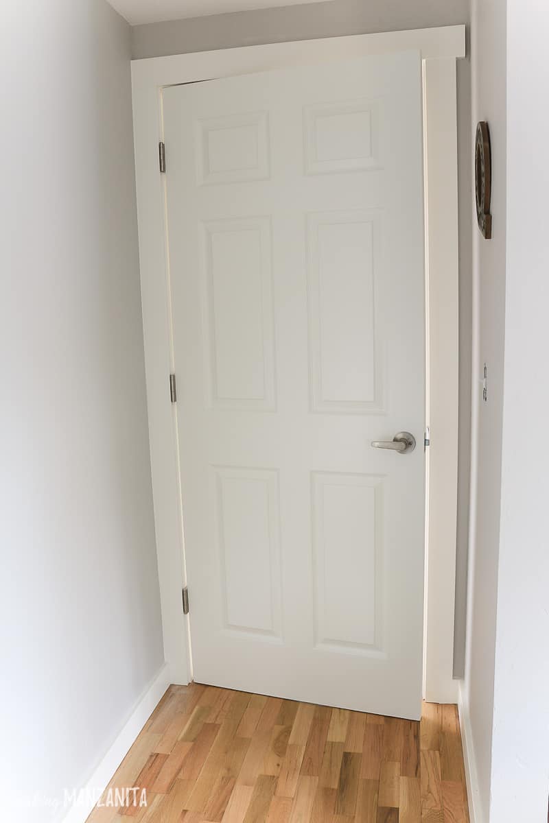 Interior door in bedroom that is white with gray walls and white trim