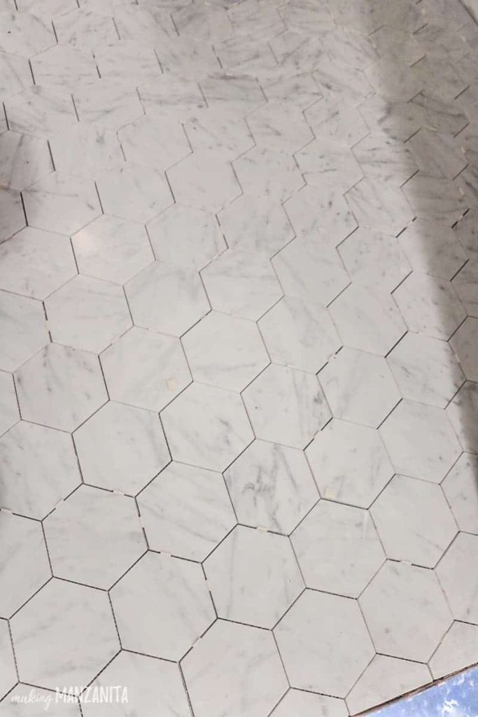 Hexagon tile flooring in bathroom while installing with spacers still in it and missing grout