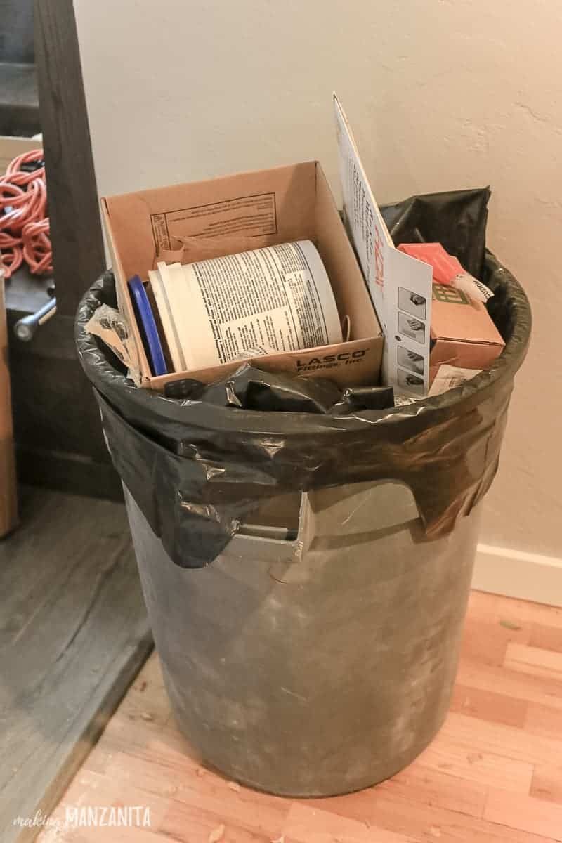 A large trash bin packed with renovation debris.