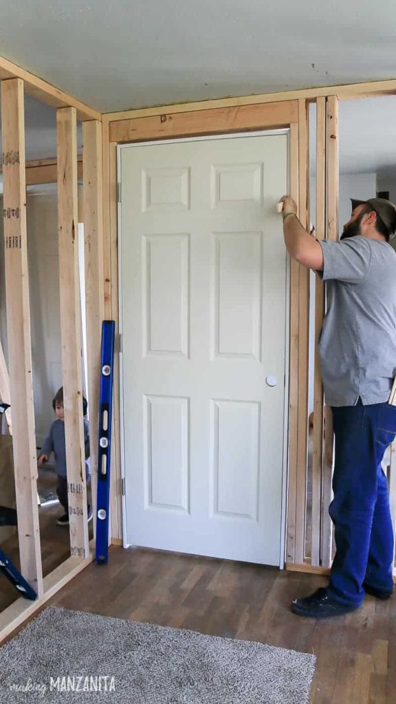 Man installing shims around a door frame 