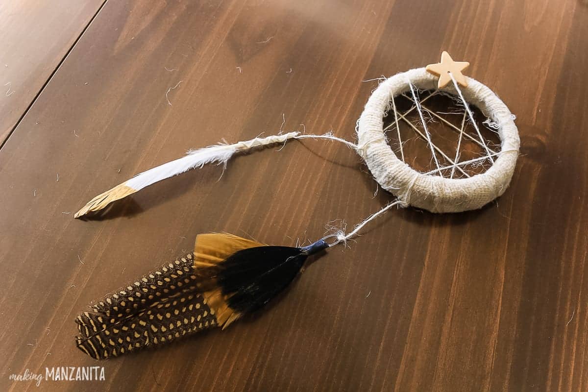 Decorative feathers attached to a mini dreamcatcher ornament.