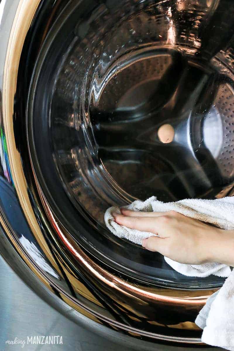 Using a wet rag to clean dampened with vinegar and water solution, wipe down the inside of your washing machine, starting with the areas by the door.