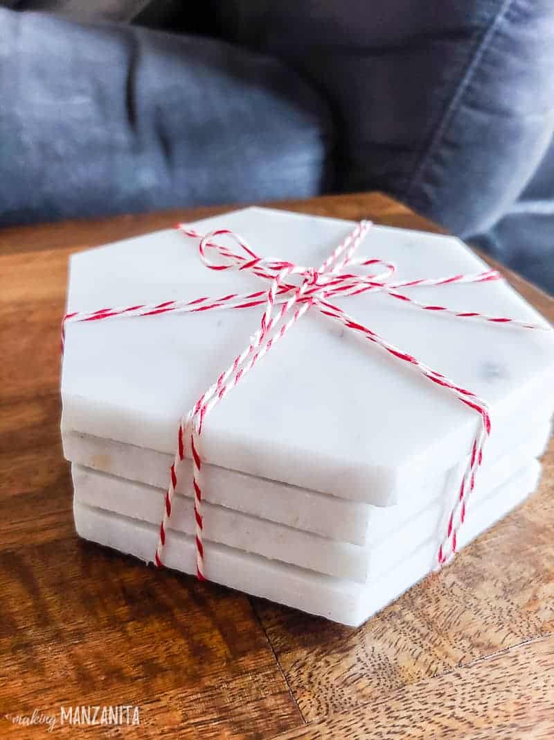 Stack of marble coasters made from hexagon tiles stacked up a wrapped with red and white baker's twine 