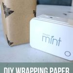Wrapped gift with brown kraft paper stamped with black Christmas trees sitting on a white table text to a Silhouette mint stamp maker with text overlay that says DIY wrapping paper with custom stamps