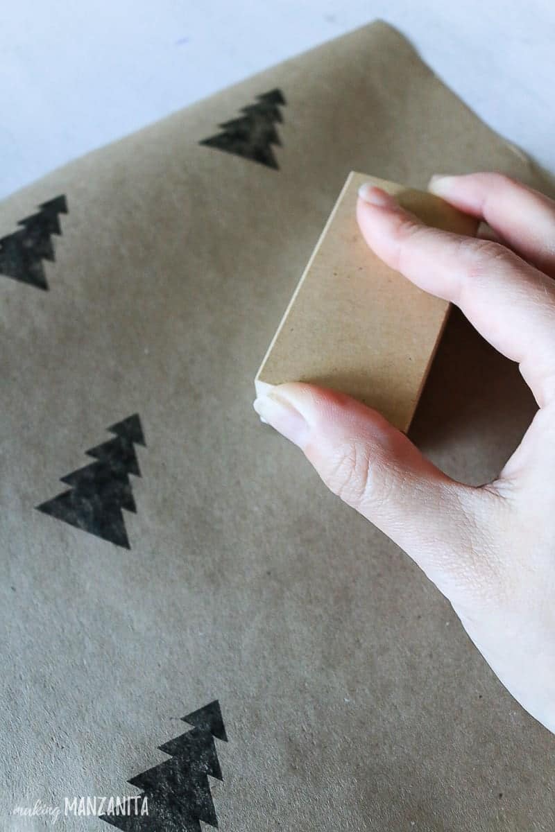Use festive holiday stamps to stamp designs onto the plain brown wrapping paper