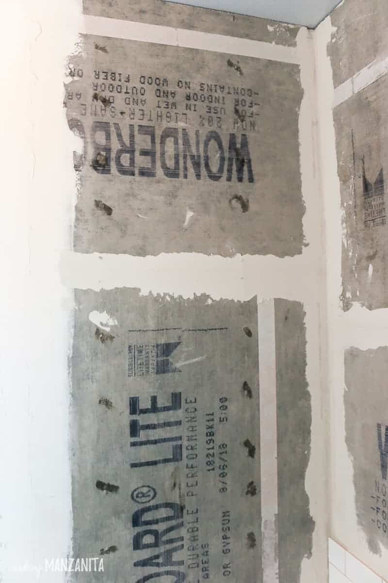 Cement panels of backer board installed in shower and bonded together at the seams with thinset and mesh tape